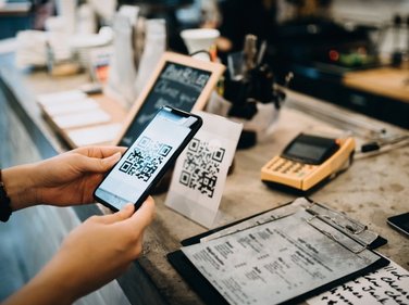 person scanning a QR code with the mobile phone